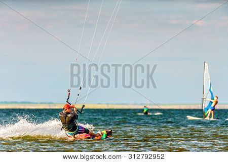 Anapa, Russia - July 9, 2017: Man Kitesurfer Rides Kite Splashing On Flat Surface Of Bugaz Firth At 