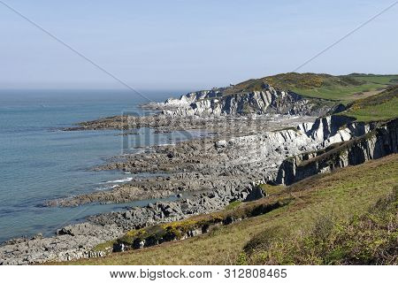 Low Tide At Rockham Beach With Bull Point Lighthouse Beyond, North Devon, Uk