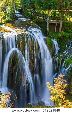 Travel to Croatia. Wonderful sunny day. The town of Slunj. Magnificent cascade of waterfalls on the Korana River. Magnificent forests surround the city and the river. The concept 