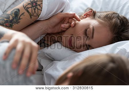 Selective Focus Of Two Lesbians Touching Each Other While Lying In Bed