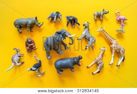 African Animals In Plastic. The Figure Of A Mammal Is Tangled In The Package. Yellow Background.