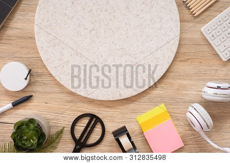 Office Table Desk Top View With Stationery, Notebook,headphone,plant,noteapd And Caculator On Wooden