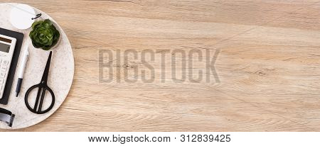 Office Table Desk Top View With Stationery, Notebook,headphone,plant,noteapd And Caculator On Wooden