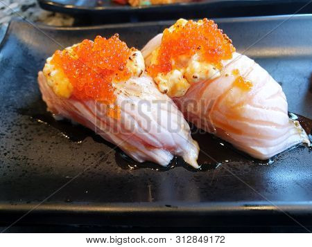 Japanese Food Style, Selective Focus Of Salmon Sushi Or Salmon Aburi Sushi With Teriyaki Sauce On Bl