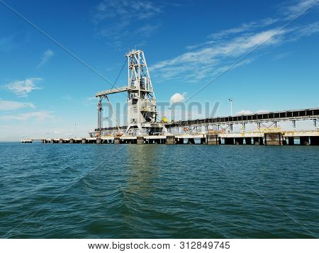 Export Coal Shipping Terminal With Loading Gantry Crane In Port Gladstone Harbour. Tropical Waterfro