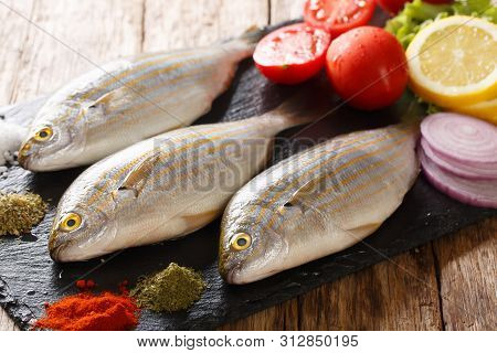 Raw Sarpa Salpa With Ingredients Close-up On A Slate Board. Horizontal