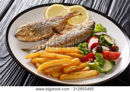 Traditional Fried Sarpa Salpa Fish With Lemon And Side Dish Of Fresh Vegetable Salad. French Fries C