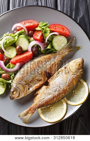 Delicious Fried Salpa Fish With Fresh Vegetable Salad Close-up On A Plate.  Vertical Top View