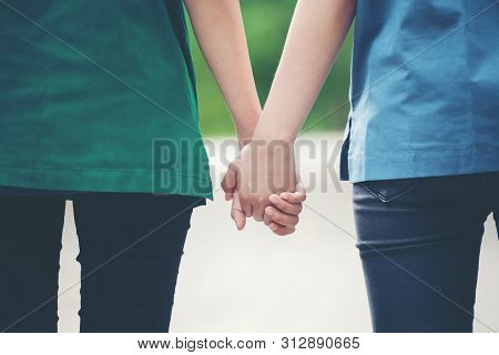Two Asian Woman Holding Hands