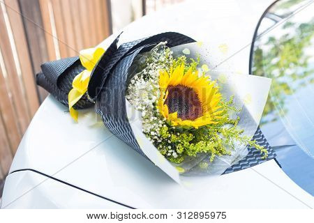 A Bouquet Of Sunflower On A White Car