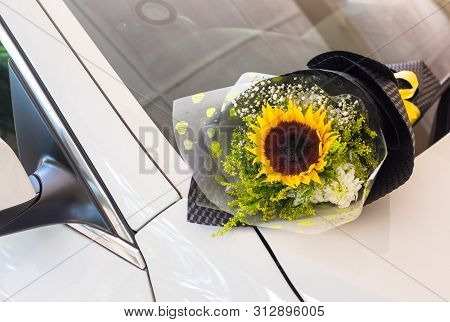 A Bouquet Of Sunflower On A White Car