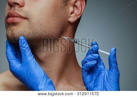 Close-up Portrait Of Young Man Isolated On Grey Studio Background. Filling Surgery Procedure. Concep