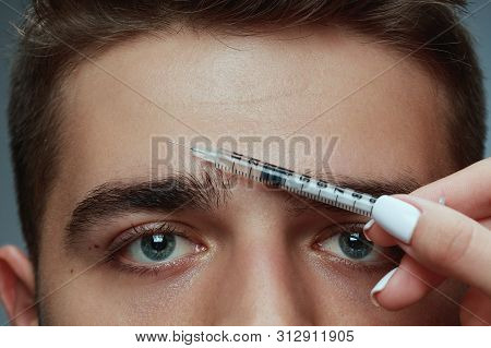 Close-up Portrait Of Young Man Isolated On Grey Studio Background. Filling Surgery Procedure. Concep