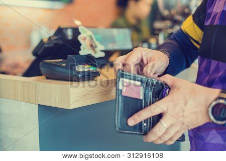 Selective Focus To Credit Card Reader With Blurry The Man Picking Up Banknotes Or Credit Card In The