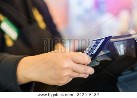 Selective Focus To The Cashier Is Swiping The Credit Card Or Member Card At The Card Reader With The