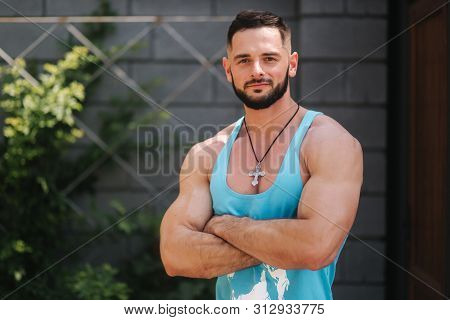 Handsome Bodybuilder In Blue Singlet Posing Outside. Bearden Men Before Training