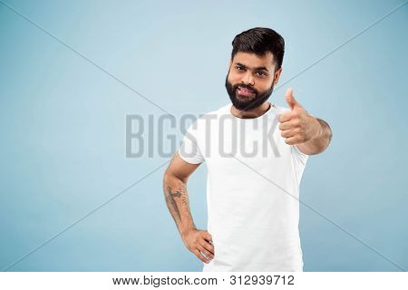 Half-length Close Up Portrait Of Young Hindoo Man In White Shirt On Blue Background. Human Emotions,
