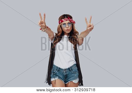 Attractive Stylish Young Woman Looking At Camera And Puckering While Standing Against Grey Backgroun