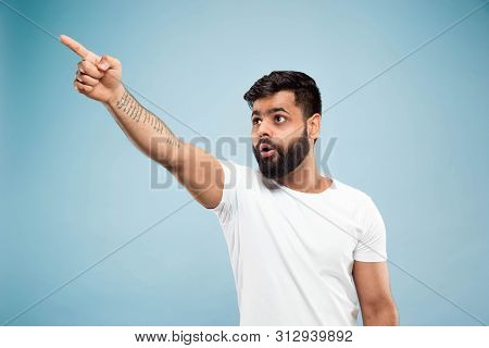 Half-length Close Up Portrait Of Young Hindoo Man In White Shirt On Blue Background. Human Emotions,