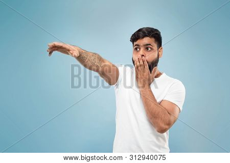 Half-length Close Up Portrait Of Young Hindoo Man In White Shirt On Blue Background. Human Emotions,