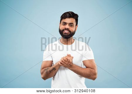 Half-length Close Up Portrait Of Young Hindoo Man In White Shirt On Blue Background. Human Emotions,
