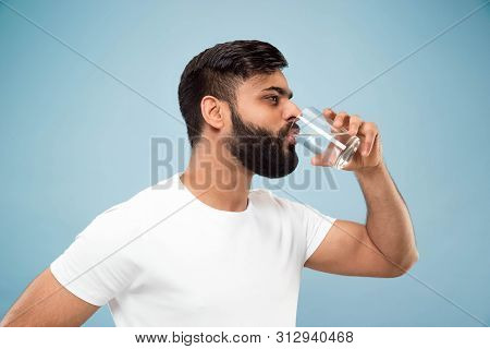 Half-length Close Up Portrait Of Young Hindoo Man In White Shirt On Blue Background. Human Emotions,