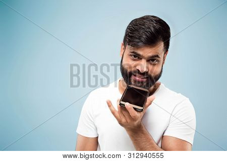 Half-length Close Up Portrait Of Young Hindoo Man In White Shirt On Blue Background. Human Emotions,