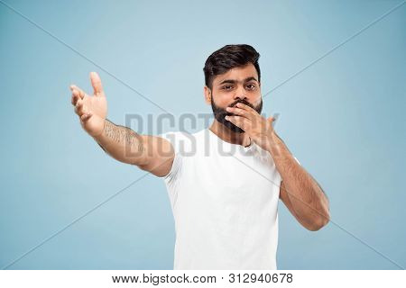Half-length Close Up Portrait Of Young Hindoo Man In White Shirt On Blue Background. Human Emotions,
