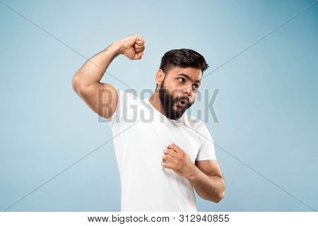 Half-length Close Up Portrait Of Young Hindoo Man In White Shirt On Blue Background. Human Emotions,