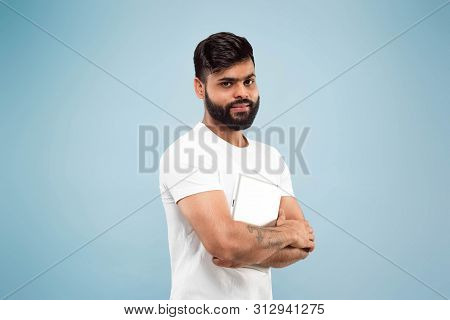 Half-length Close Up Portrait Of Young Hindoo Man In White Shirt On Blue Background. Human Emotions,
