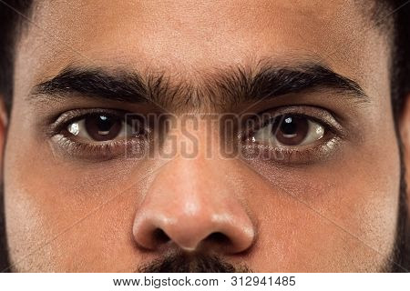Close Up Portrait Of Young Hindoo Mans Face With Brown Eyes Looking Right At Camera. Human Emotions,