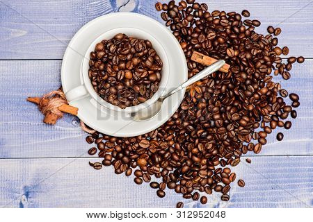 Caffeine Concept. Inspiration And Energy Charge. Cup Full Coffee Brown Roasted Bean Blue Wooden Back