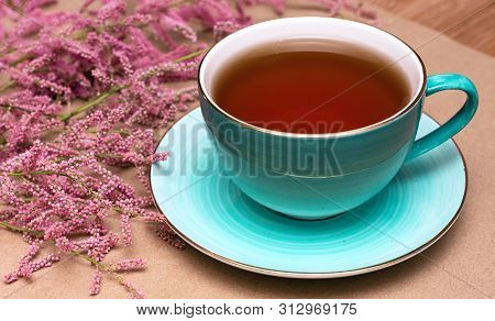 Cup Of Hot Tea And A Tamarix Gallica Tree Branches On A Brown Background.