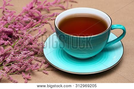 Cup Of Hot Tea And A Tamarix Gallica Tree Branches On A Brown Background.