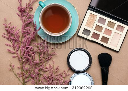 Make Up Concept Flat Lay Background. Make Up Brushes And Cosmetics, Cup Of Tea And A Blooming Tamari