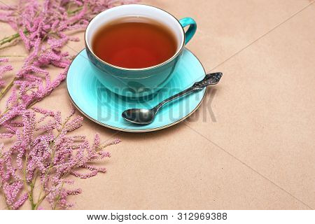 Cup Of Hot Tea And A Tamarix Gallica Tree Branches On A Brown Background.