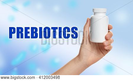 Woman Holding Bottle Of Pills On Light Blue Background, Closeup. Prebiotic Supplements