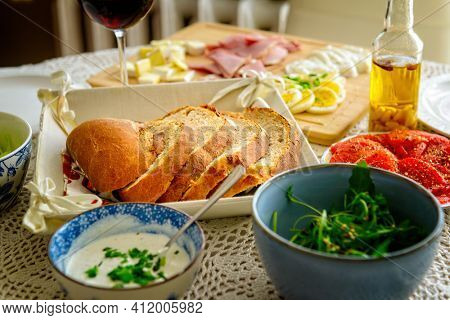 Loaf of bread cut into slices. Continental, healthy breakfast containing homemade bread and a vegetable, cheese and egg, olive, ham Bread based on spelt and rye flour with the addition of wheat flou
