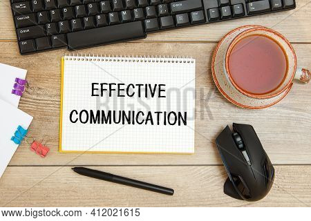 Office Desk And Notebook With Text Effective Communication, Keyboard And A Cup Of Tea