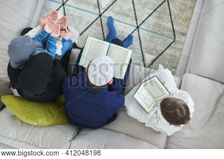 Top view of young muslim family reading Quran during Ramadan