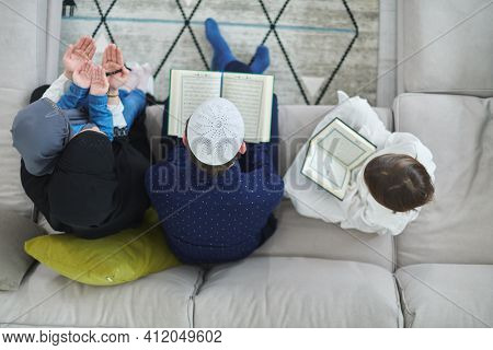 Top view of young muslim family reading Quran during Ramadan