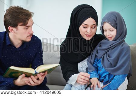 Young muslim family reading Quran during Ramadan