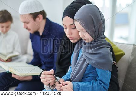 Young muslim family reading Quran during Ramadan