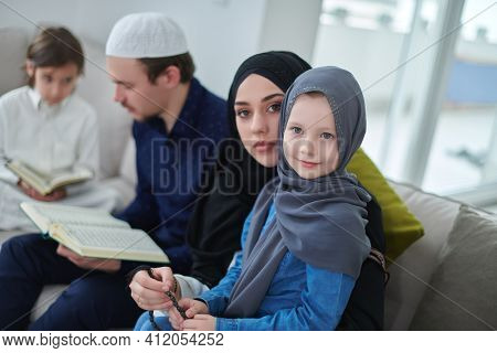 Young muslim family reading Quran during Ramadan