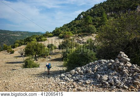Hiking Lycian way. Man is walking on dry stony highland on stretch between Kalkan and Kas of Lycian way trail, Trekking in Turkey, outdoor activity