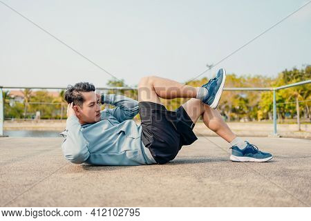 Young Sportsman Doing Cyling Crunches In Park.