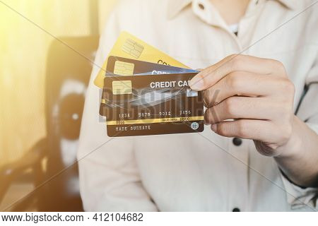 Cropped Shot View Of Female Hands Showing Her Credit Cards. Credit Card Lets Cardholders Borrow Fund