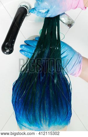 High-angle Shot Of Hairdresser In Gloves Washes Clients Head With Long Hair Sapphire Color After Hai