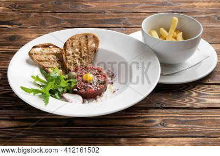 Beef Tartare With French Fries, Quail Egg, Arugula Salad, Radish, Capers And Grilled Ciabata