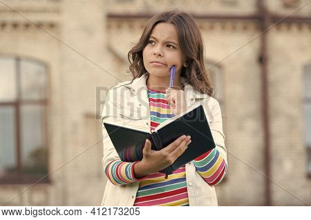 Imaginative World. Little Child Hold Book With Thoughtful Look. Nurturing Childhood Imagination. Ima